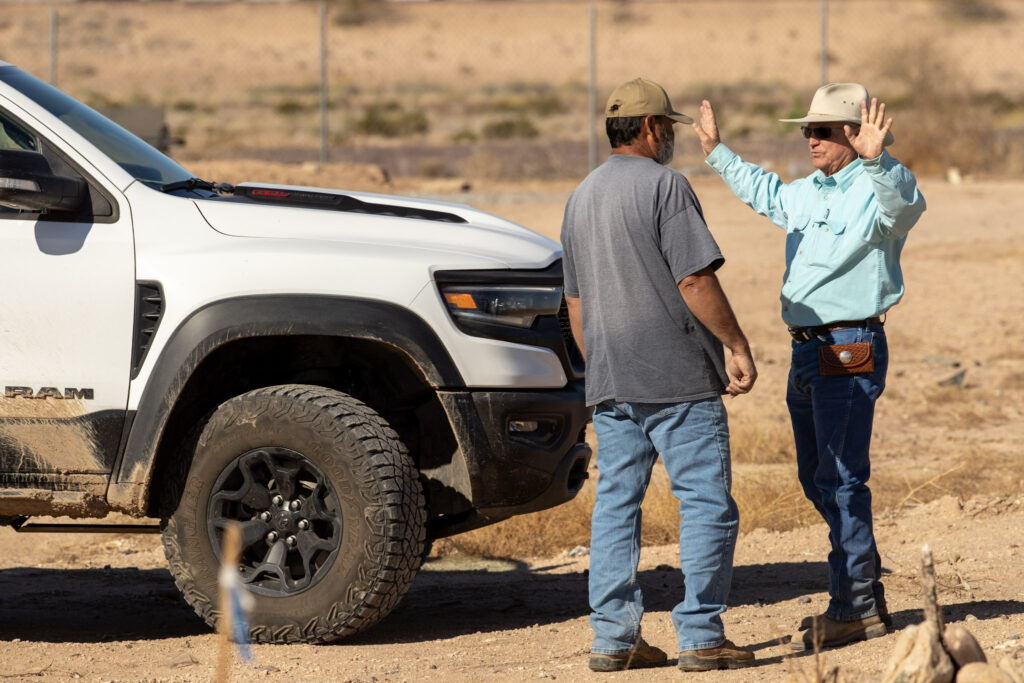 Stephen H. Williams discusses water delivery strategy with a fellow farmer next to a white Ram truck on the Laveen farm. These conversations are where practical know-how and SRP coordination come together to keep Arizona agriculture running strong.